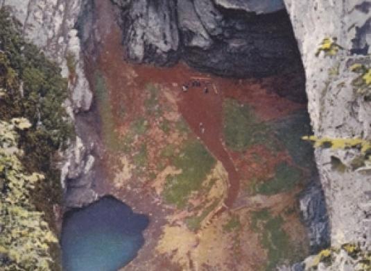 Kopcovité ohromné dno světoznámé propasti Macochy s dvěma jezírky. Horní část klenutá jest stropem zřícené jeskyně, jejíž prostory pokračují dvěma příšernými komíny do výšky (1919)